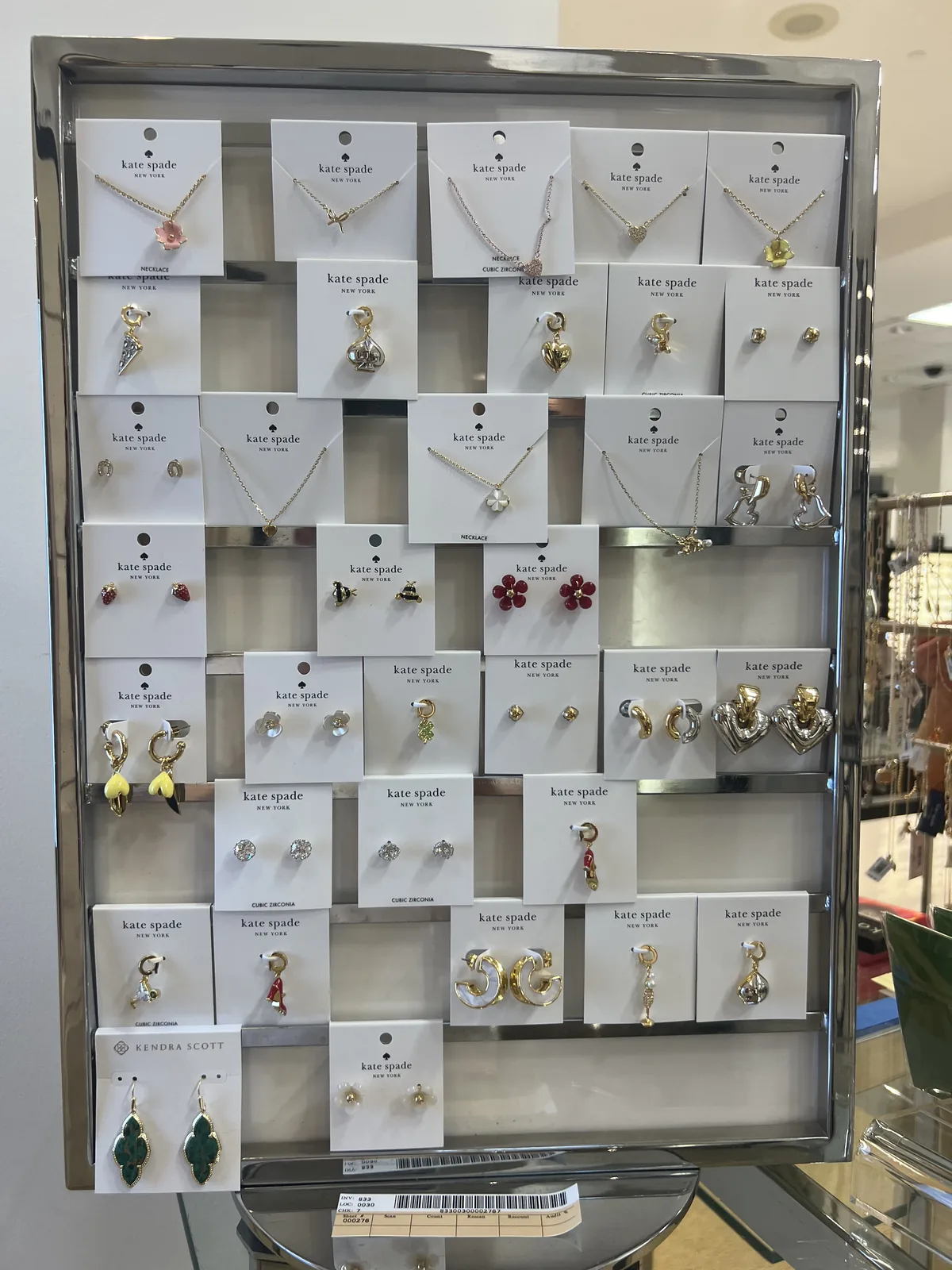Bloomingdale's 内 kate spade 饰品陈列板,白底黑桃卡片上的锆石与珐琅花朵耳饰项链