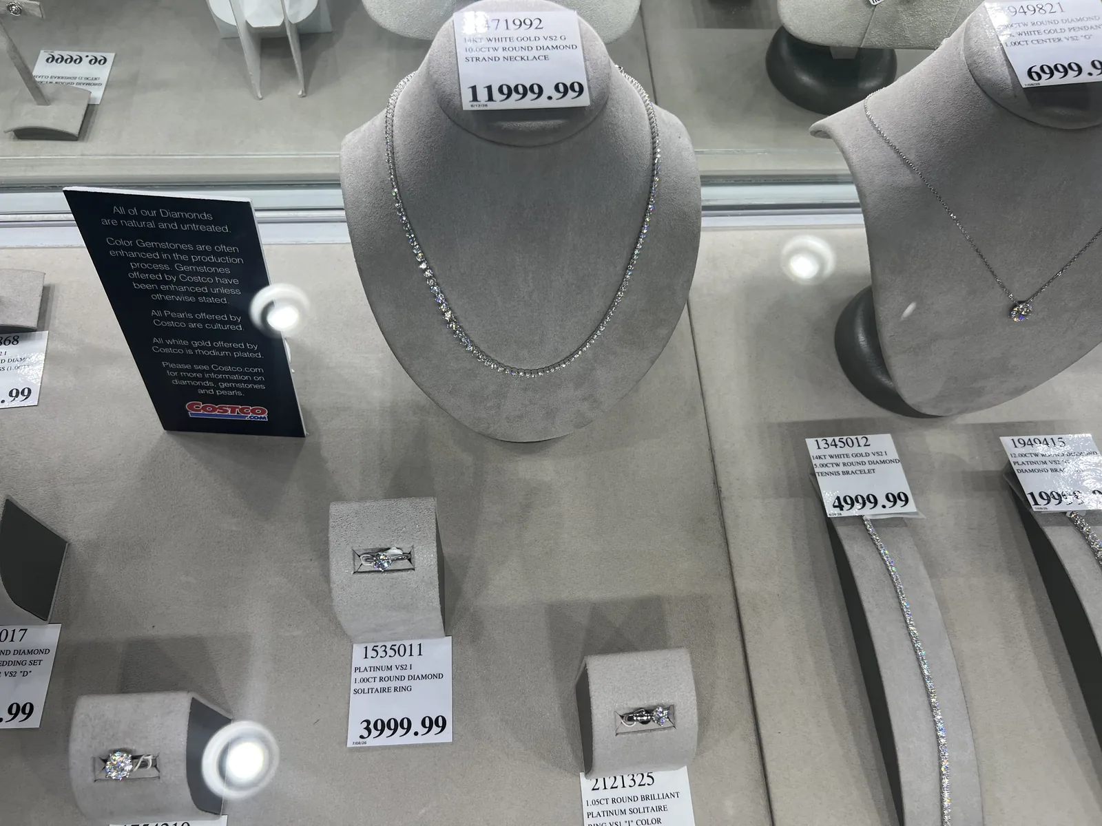 Costco 钻石柜台,网球项链标 11999.99 美元,单钻戒标 3999.99 美元,标签印有 4C