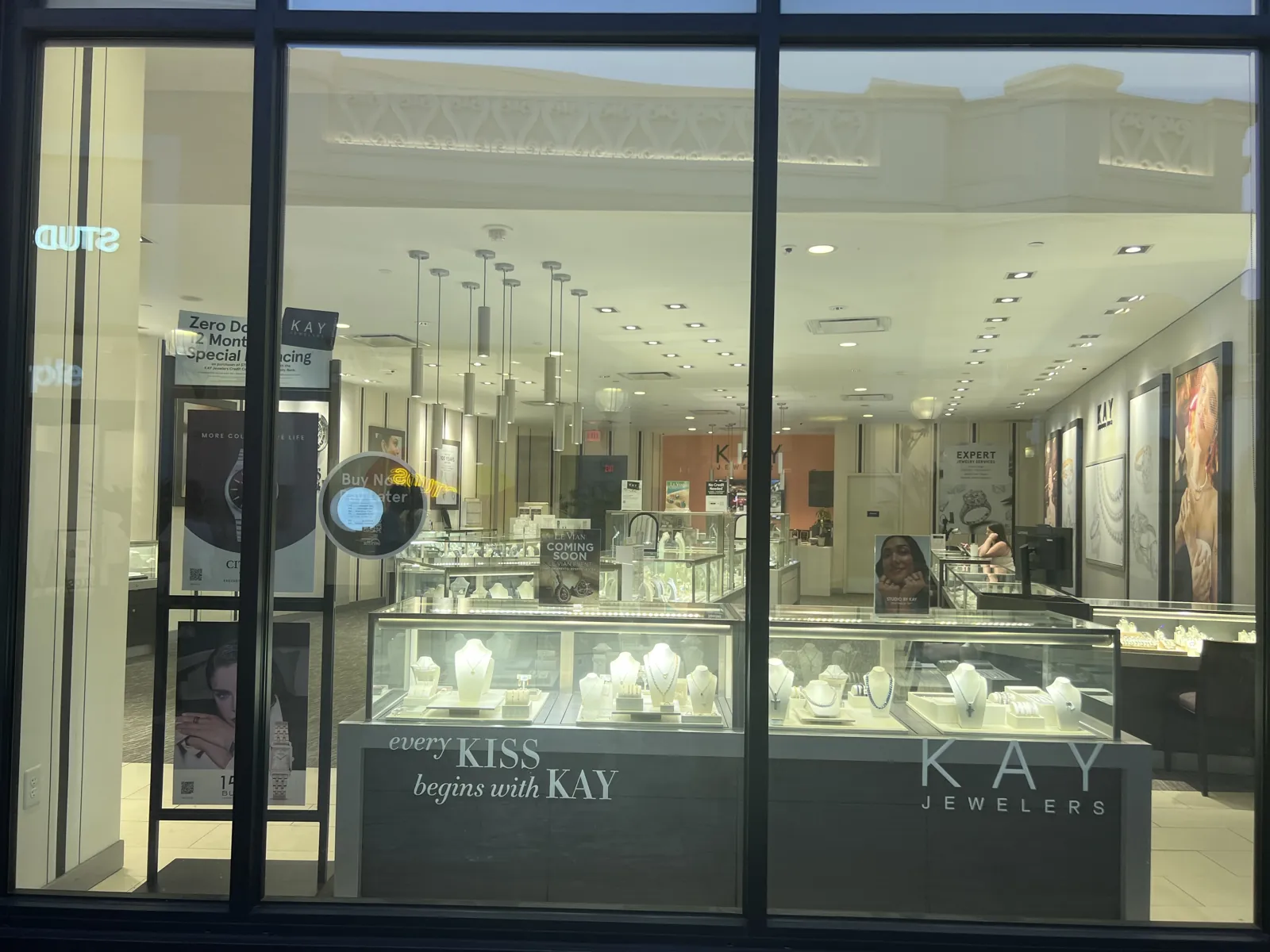Kay Jewelers 橱窗内景与 every KISS begins with KAY 标语、玻璃展柜
